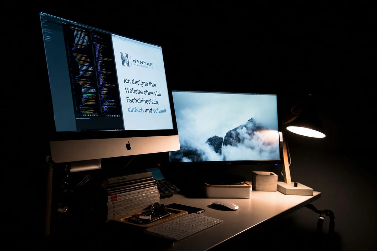 Arbeitsplatz mit zwei Bildschirmen, auf dem linken eine Website von Hannak Solutions